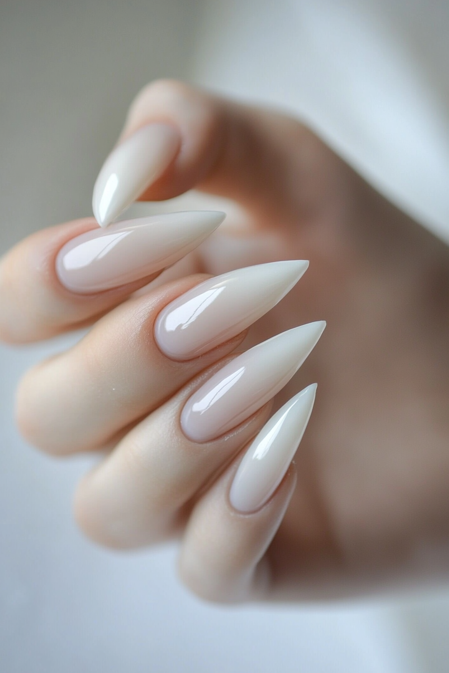 Minimalist almond nails in soft pink with a gold accent, set against a light background.
