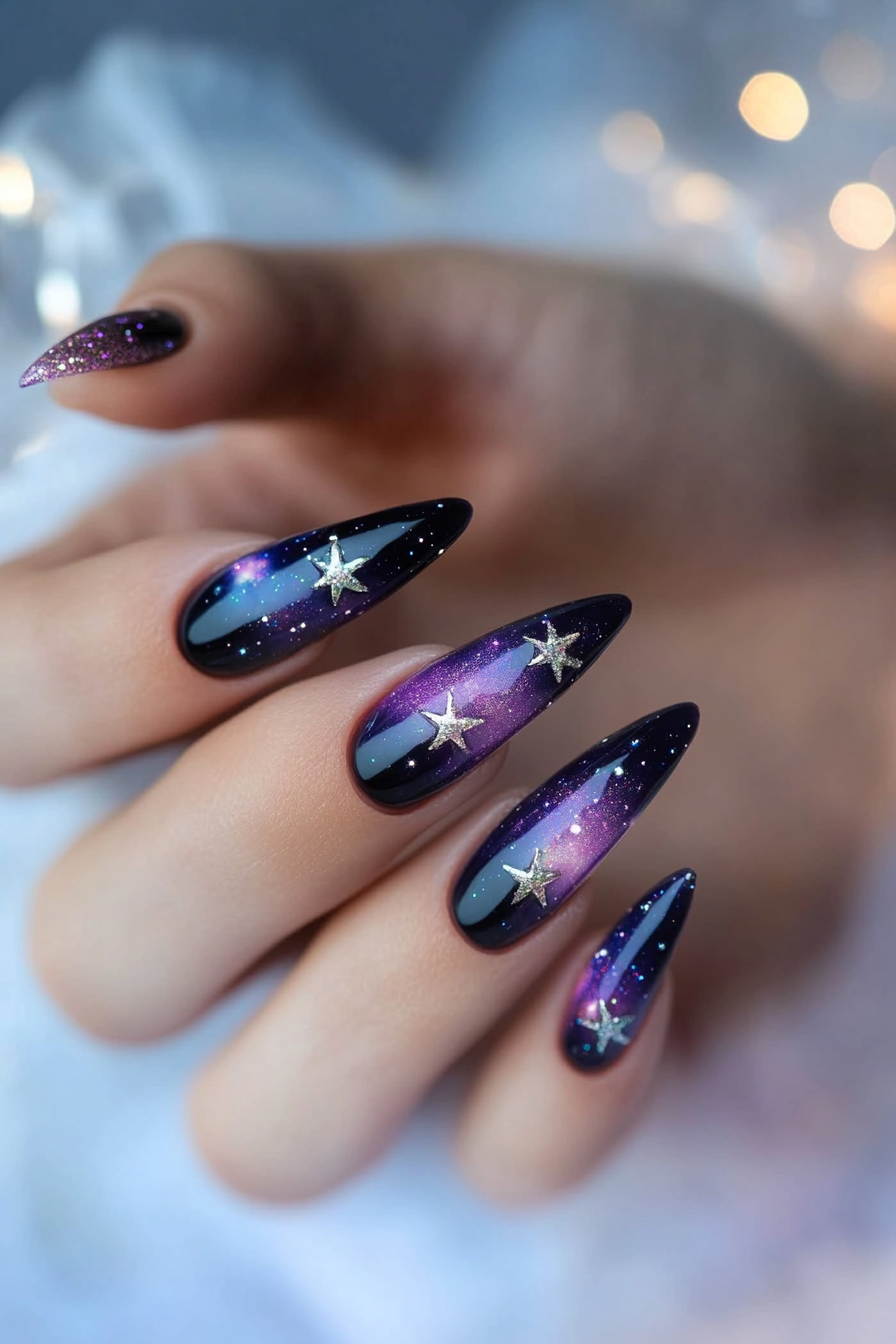 Nail design featuring a night sky theme with stars and a moon on almond-shaped nails