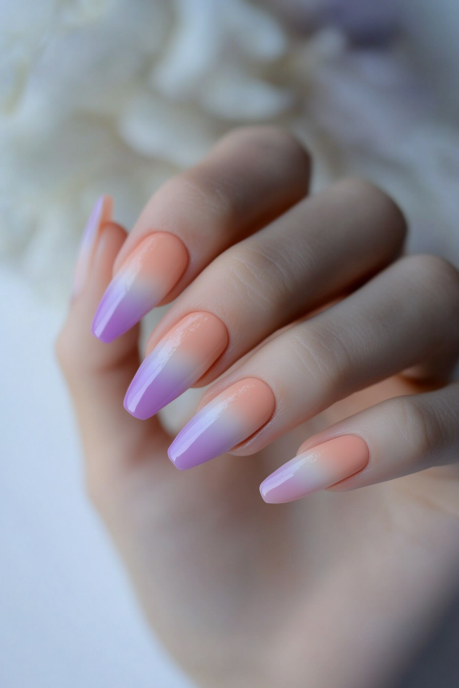 Nails featuring a pastel sunset gradient design in yellow and pink.