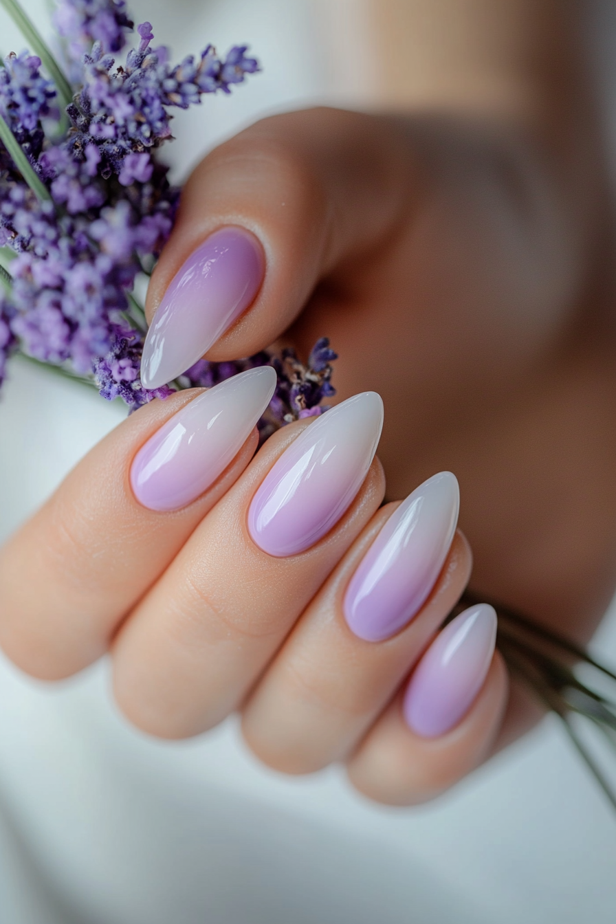 Nail art featuring lavender and lilac flower designs on almond-shaped nails.
